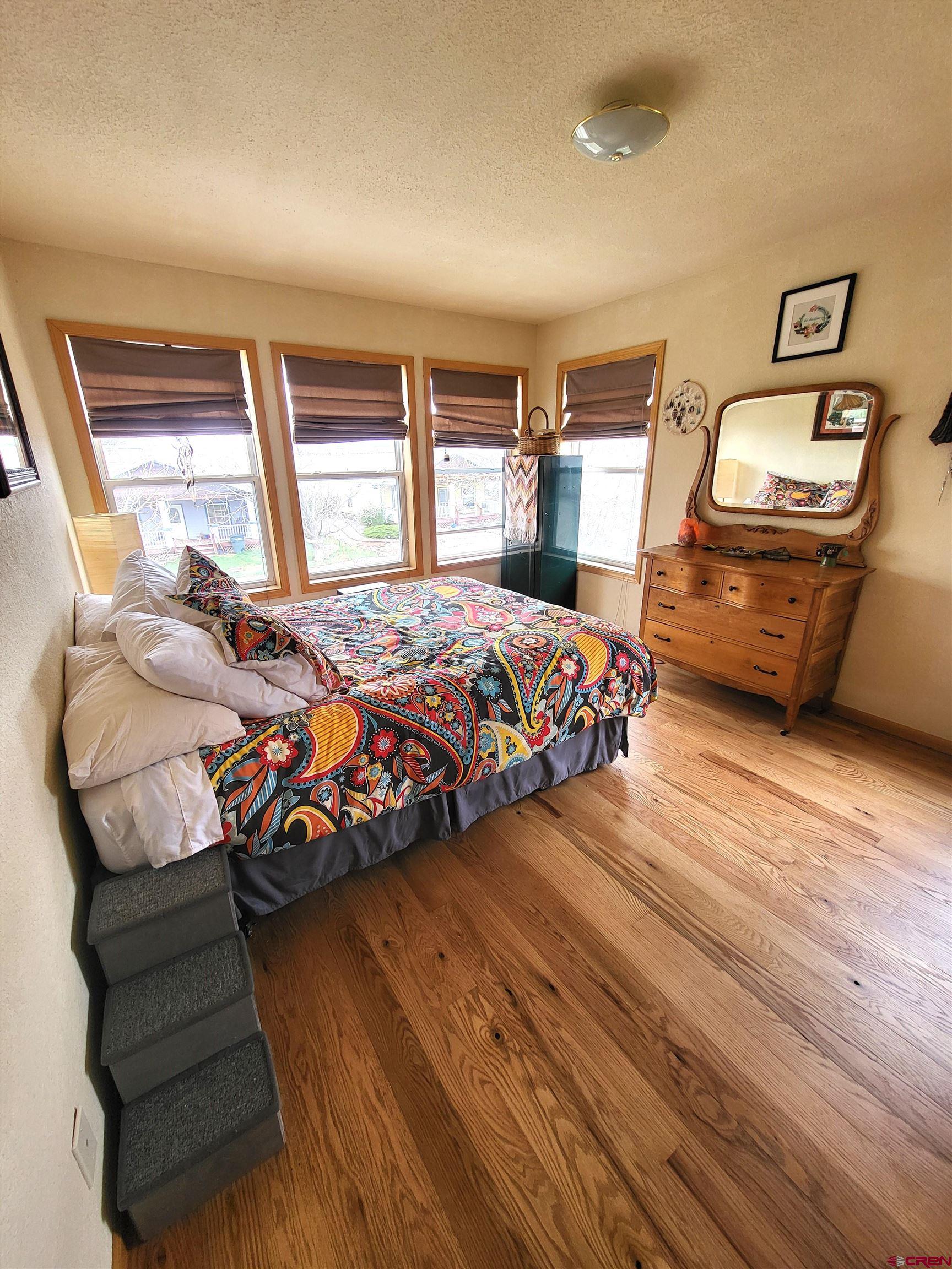 1610 Pine Street, Unit E Norwood, CO 81423 - Photo 15 of 23 a bedroom with a bed and wooden floor