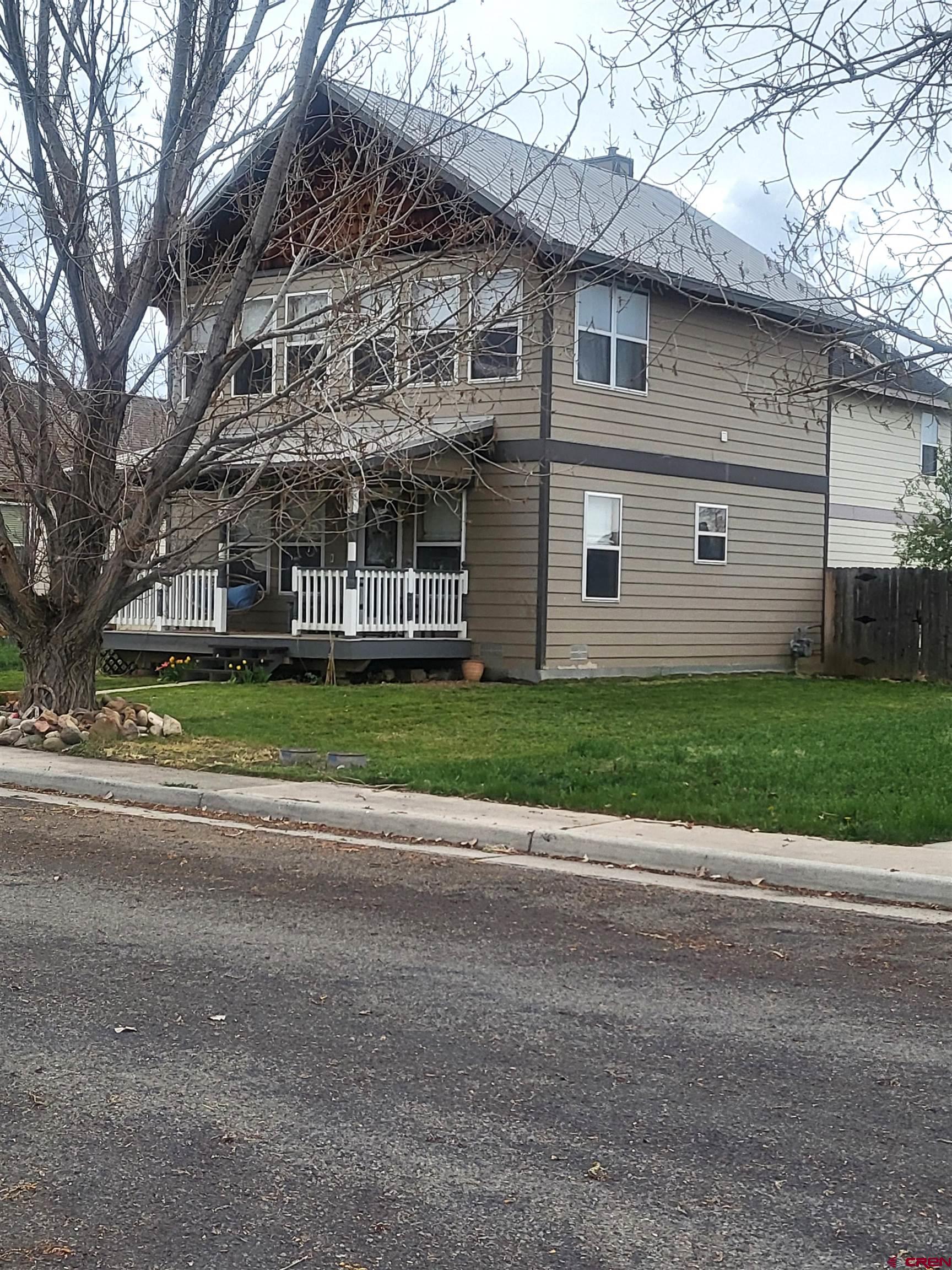 1610 Pine Street, Unit E Norwood, CO 81423 - Photo 2 of 23 a view of a large building with large windows and a big yard and large trees