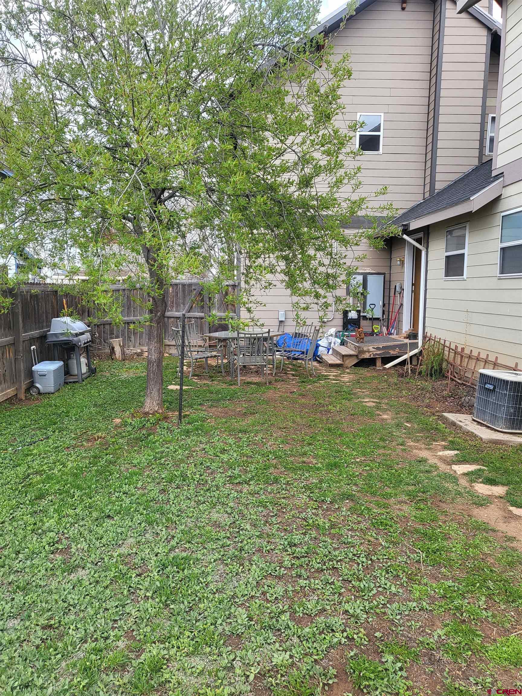 1610 Pine Street, Unit E Norwood, CO 81423 - Photo 22 of 23 a view of a backyard with table and chairs and a large tree