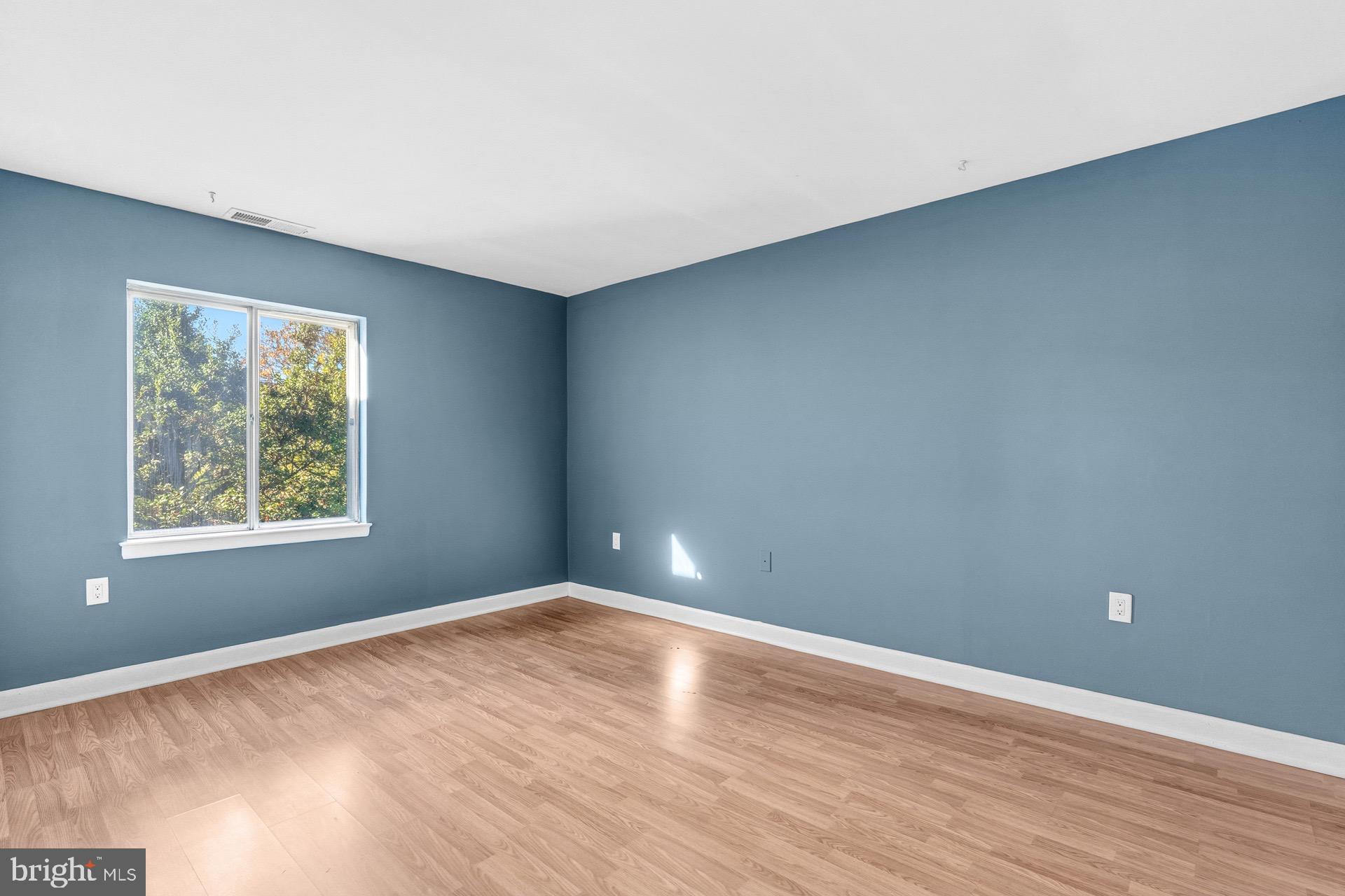 422 Girard Street, Unit 144 Gaithersburg, MD 20877 - Photo 23 of 26 an empty room with wooden floor and windows