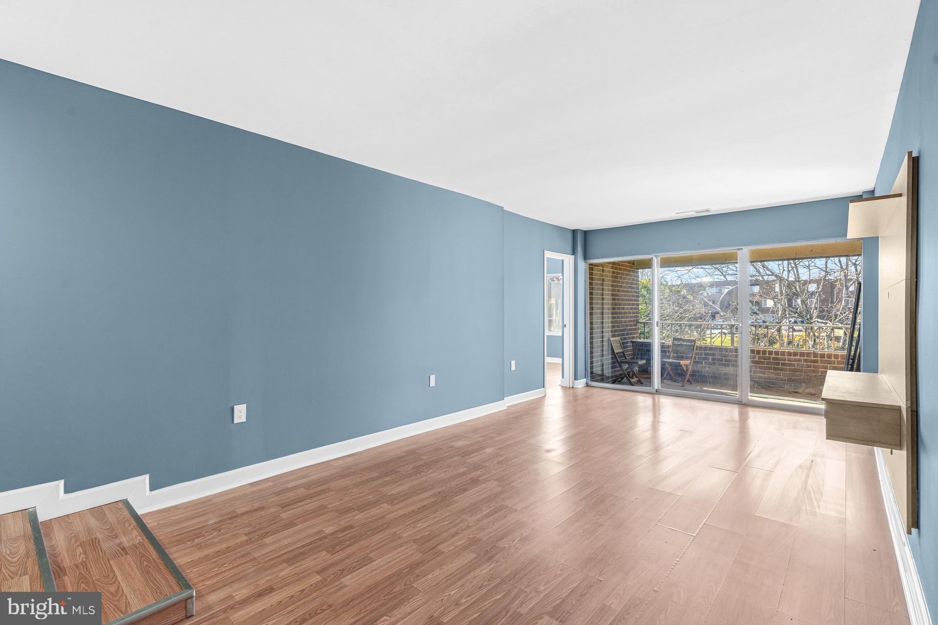 422 Girard Street, Unit 144 Gaithersburg, MD 20877 - Photo 4 of 26 a view of an empty room with wooden floor and a window