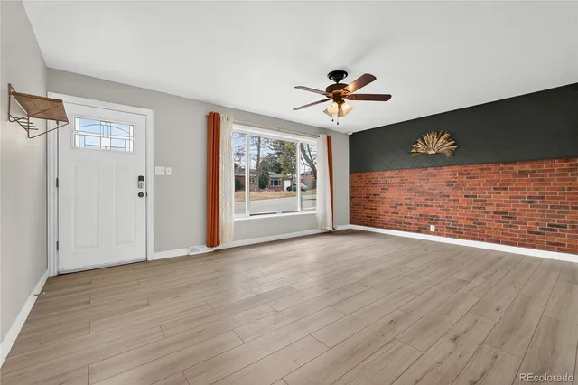 a view of a livingroom with a ceiling fan window and wooden floor