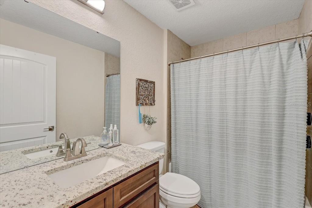 7314 Madrid Road Weeki Wachee, FL 34613 - Photo 25 of 54 a bathroom with a granite countertop sink and a mirror