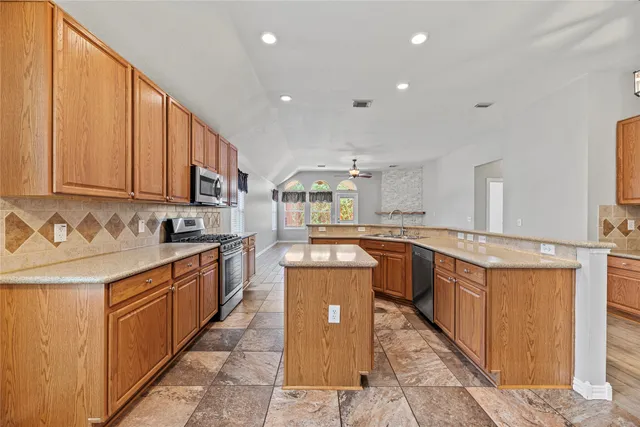 a large kitchen with stainless steel appliances granite countertop a large stove a sink and a refrigerator