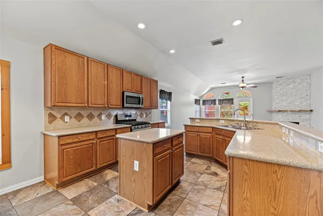 a kitchen with a sink stove top oven and cabinets