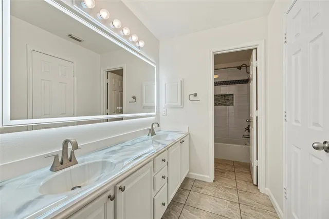 a spacious bathroom with a double vanity sink a mirror and a shower