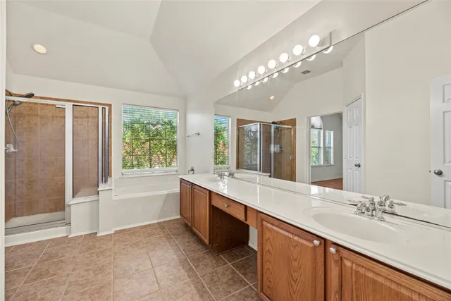 a large white bathroom with a large tub sink and double vanity