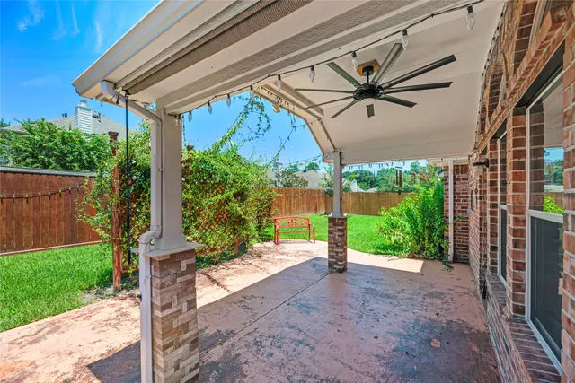 a porch with a table and chairs under an umbrella