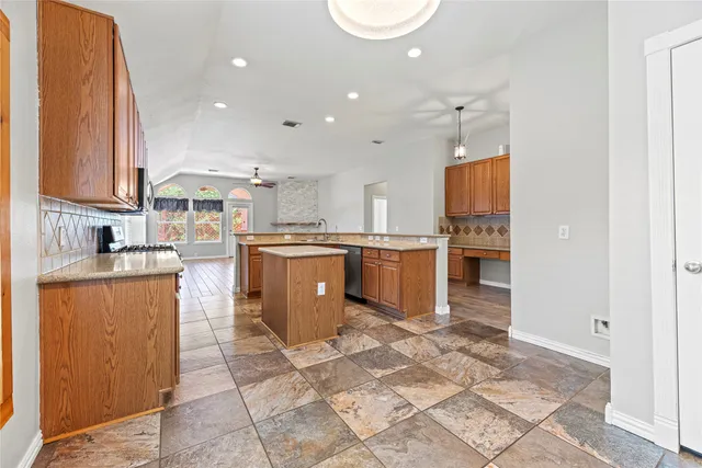a kitchen with stainless steel appliances granite countertop a stove top oven a sink a counter top space and cabinets