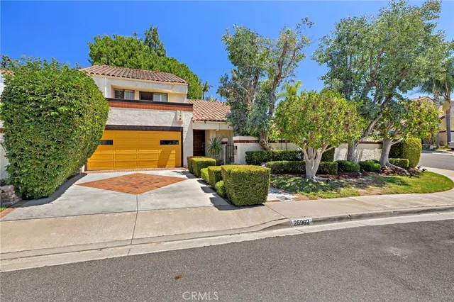 a front view of a house with a yard and potted plants