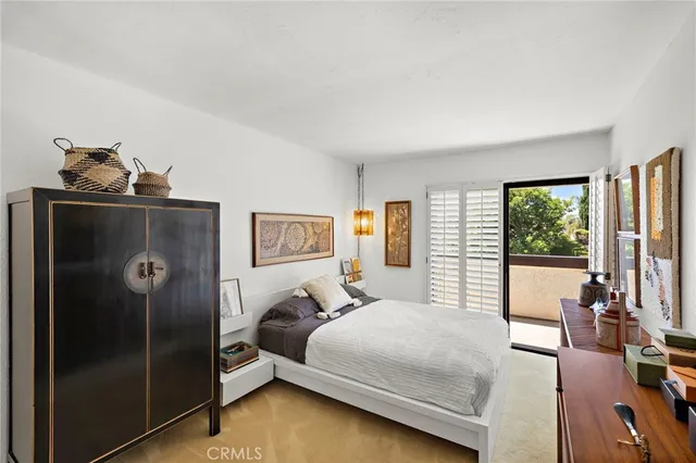 a bedroom with a bed and a dresser next to a window