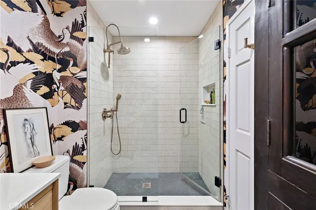 a bathroom with a granite countertop shower a toilet and a sink