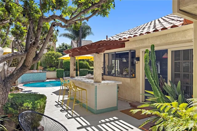a view of a patio with table and chairs potted plants and large tree