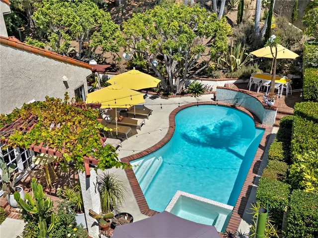 an aerial view of a house with swimming pool and outdoor seating