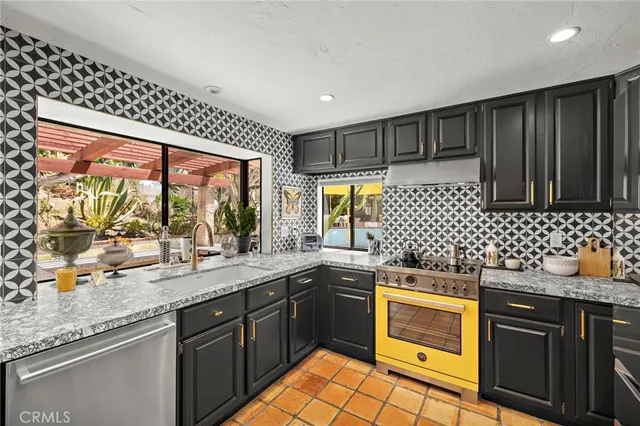 a kitchen with stainless steel appliances a sink stove and cabinets