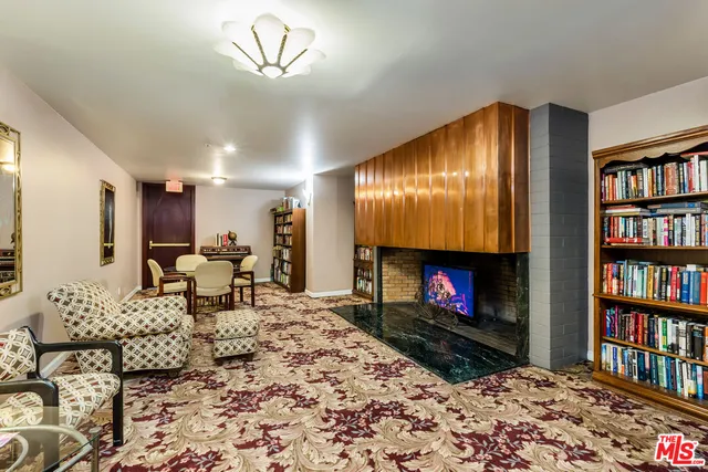 a living room with furniture a bookshelf and a fireplace