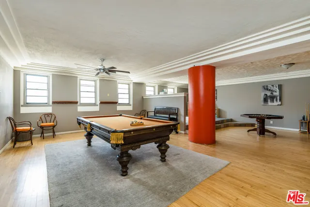 a room with pool table and windows