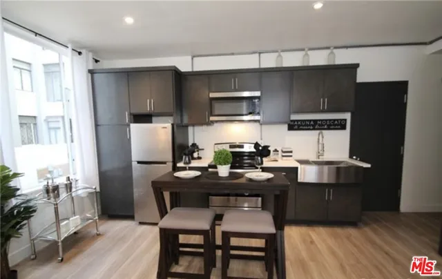 a kitchen with a table chairs refrigerator and microwave