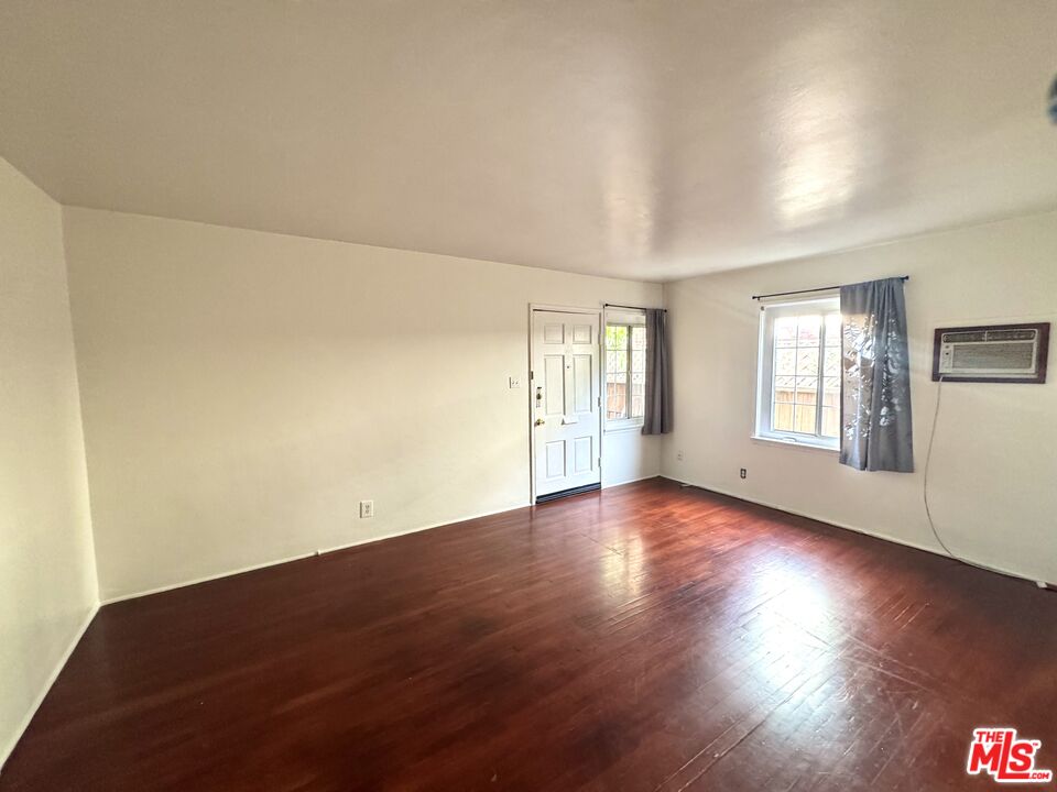 11926 West Magnolia Boulevard, Unit 1/4 Valley Village, CA 91607 - Photo 5 of 12 an empty room with wooden floor and windows