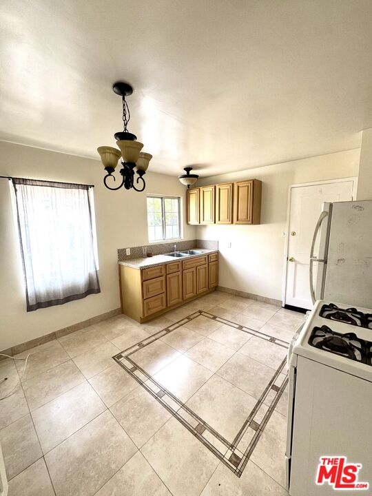 11926 West Magnolia Boulevard, Unit 1/4 Valley Village, CA 91607 - Photo 9 of 12 a kitchen with stainless steel appliances granite countertop a stove a sink and a refrigerator