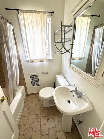 a bathroom with a sink toilet and a mirror