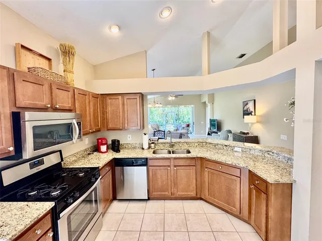 a kitchen with a sink a stove cabinets and a window