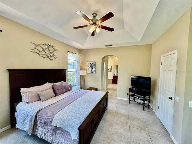 a bedroom with a large bed and a chandelier
