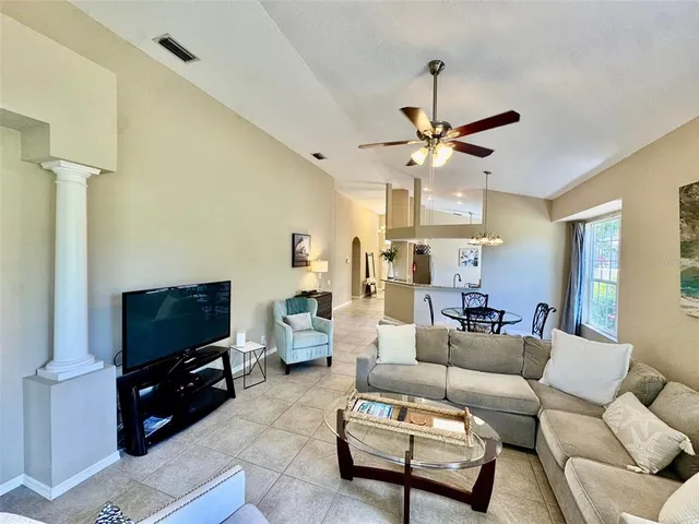 a living room with furniture a flat screen tv and a window
