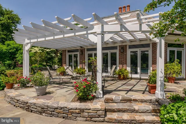 a view of a patio with table and chairs potted plants and large tree