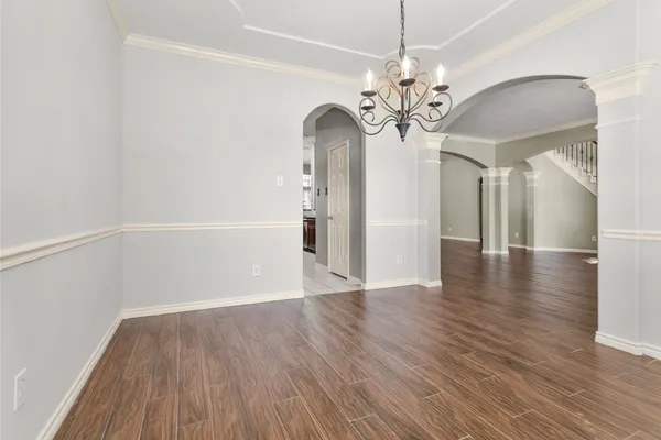 an empty room with wooden floor fireplace and windows