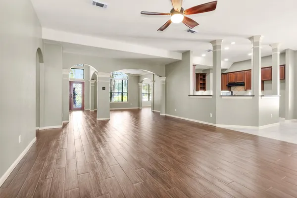 an empty room with wooden floor and a fireplace