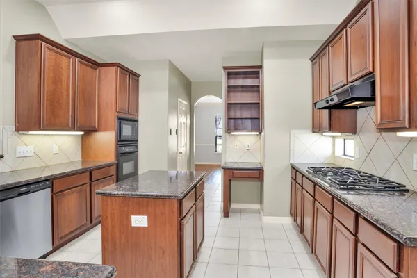 a kitchen with stainless steel appliances granite countertop a sink and a refrigerator
