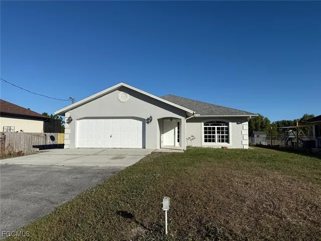 a view of a house with a yard and garage