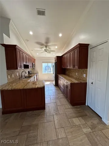 a large kitchen with stainless steel appliances granite countertop wooden cabinets a granite counter top and a stove
