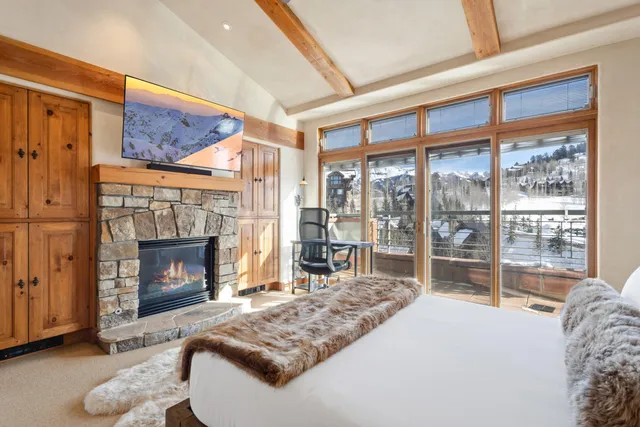 a living room with furniture a fireplace and a floor to ceiling window