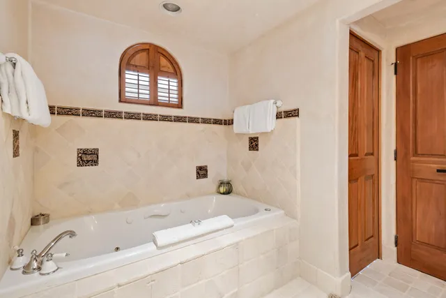 a bathroom with a tub sink and mirror