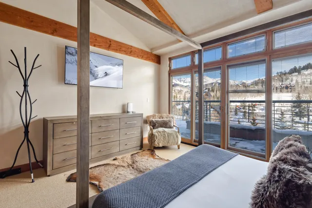 a bedroom with a large bed and windows