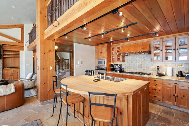 a dining hall with stainless steel appliances granite countertop a sink and a refrigerator