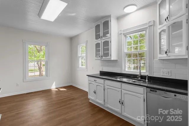 a kitchen with granite countertop wooden cabinets a sink and a window
