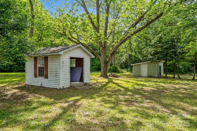 a view of a house with a yard and large tree