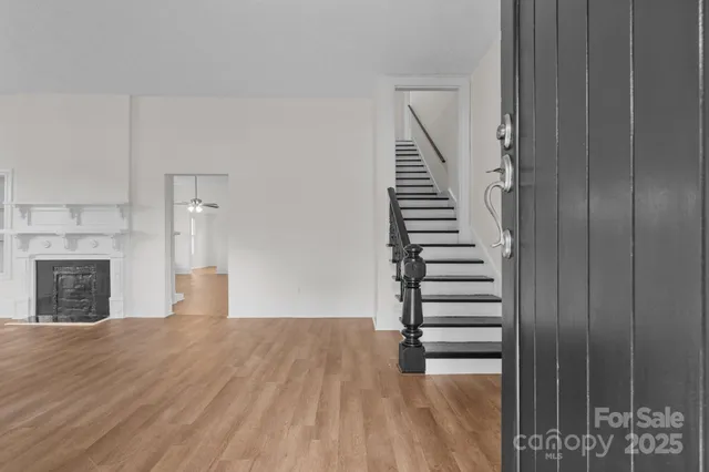 a view of a room with staircase and wooden floor