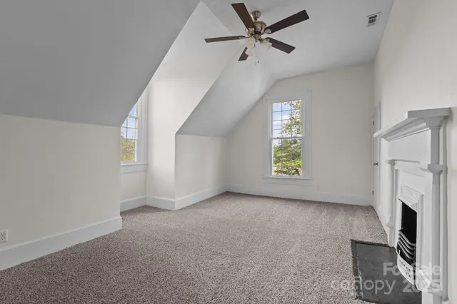 a view of an empty room with a fireplace and a window
