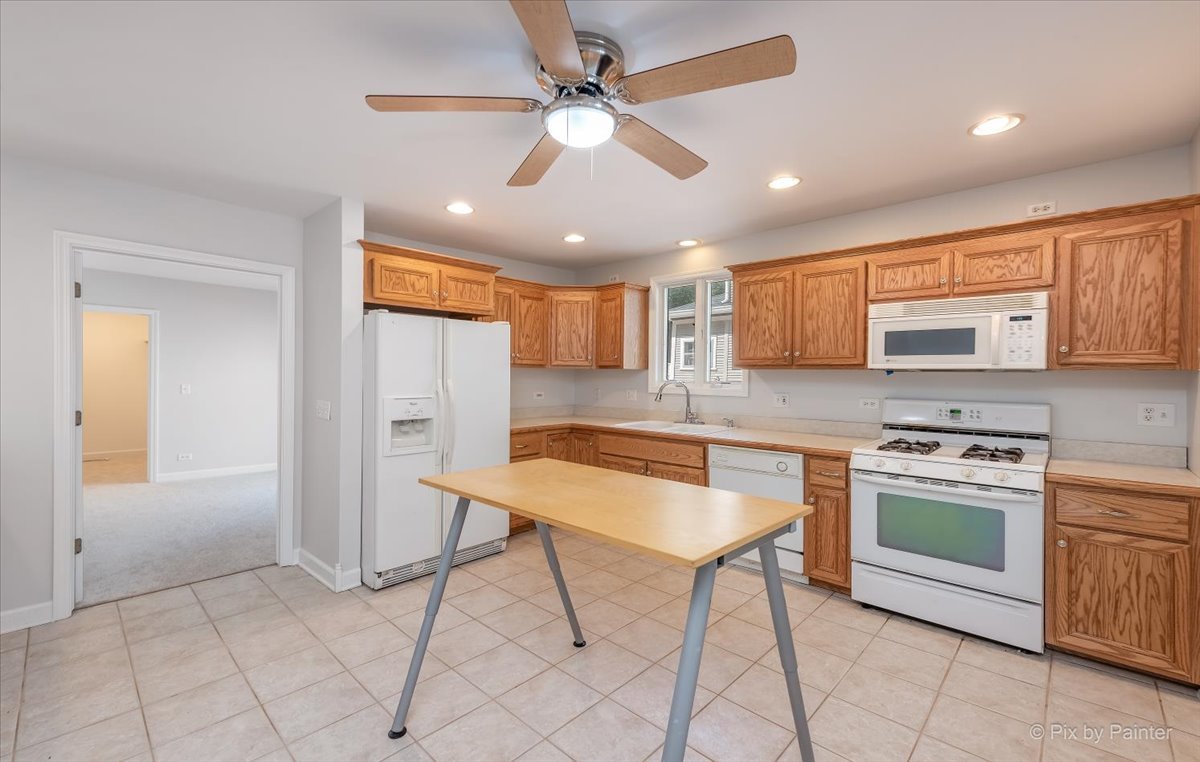 30 Crissey Avenue Geneva, IL 60134 - Photo 10 of 48 a kitchen with stainless steel appliances granite countertop a stove top oven a refrigerator a sink with a dining table and chairs