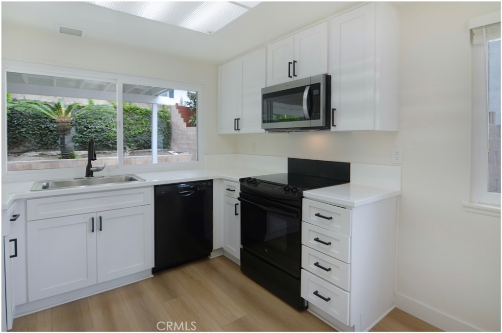 1110 Redding Avenue Costa Mesa, CA 92626 - Photo 9 of 30 a kitchen with cabinets stainless steel appliances a sink and a large window
