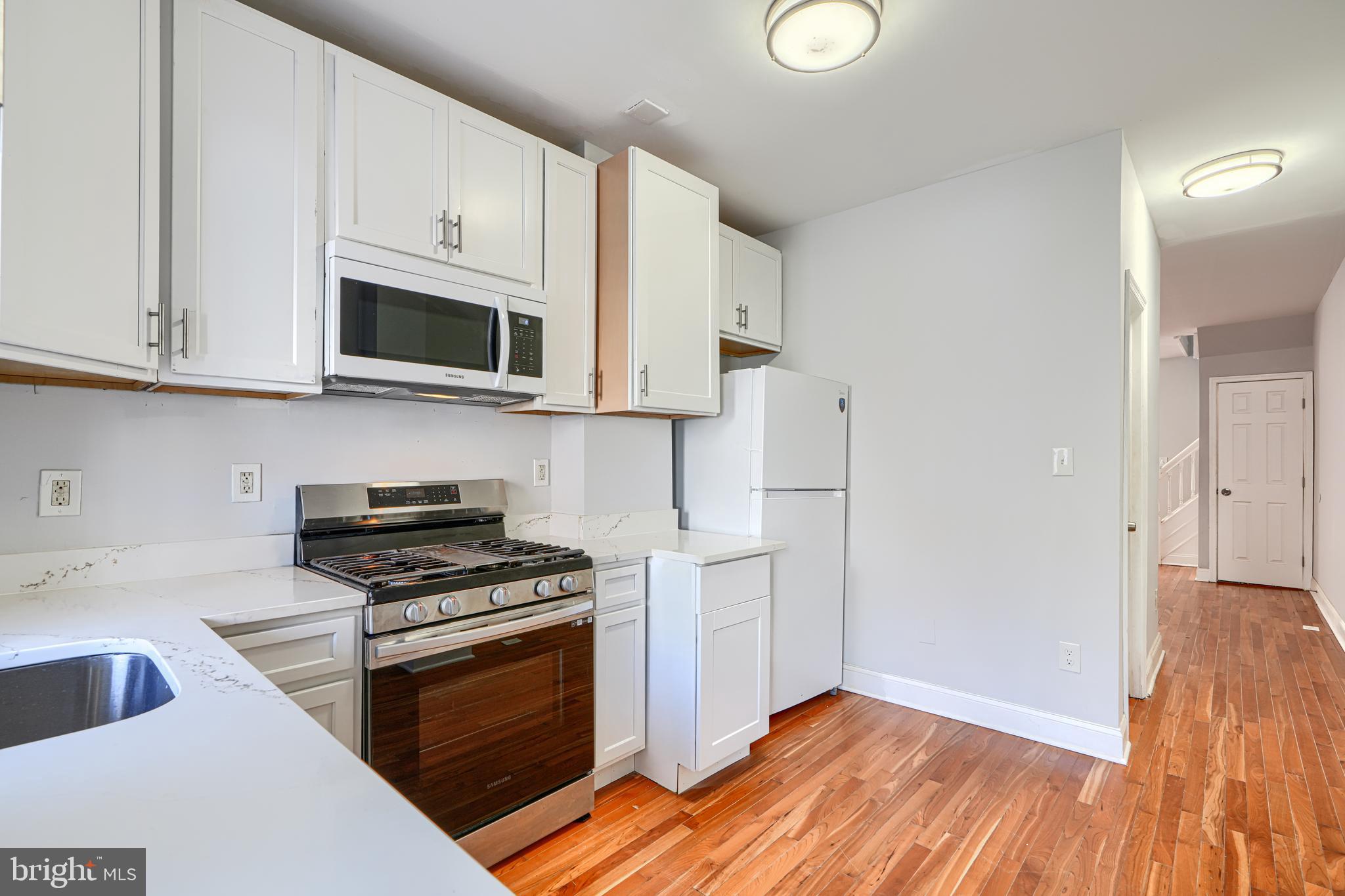 2511 McCulloh Street Baltimore, MD 21217 - Photo 16 of 35 a kitchen with stainless steel appliances a stove a microwave and cabinets
