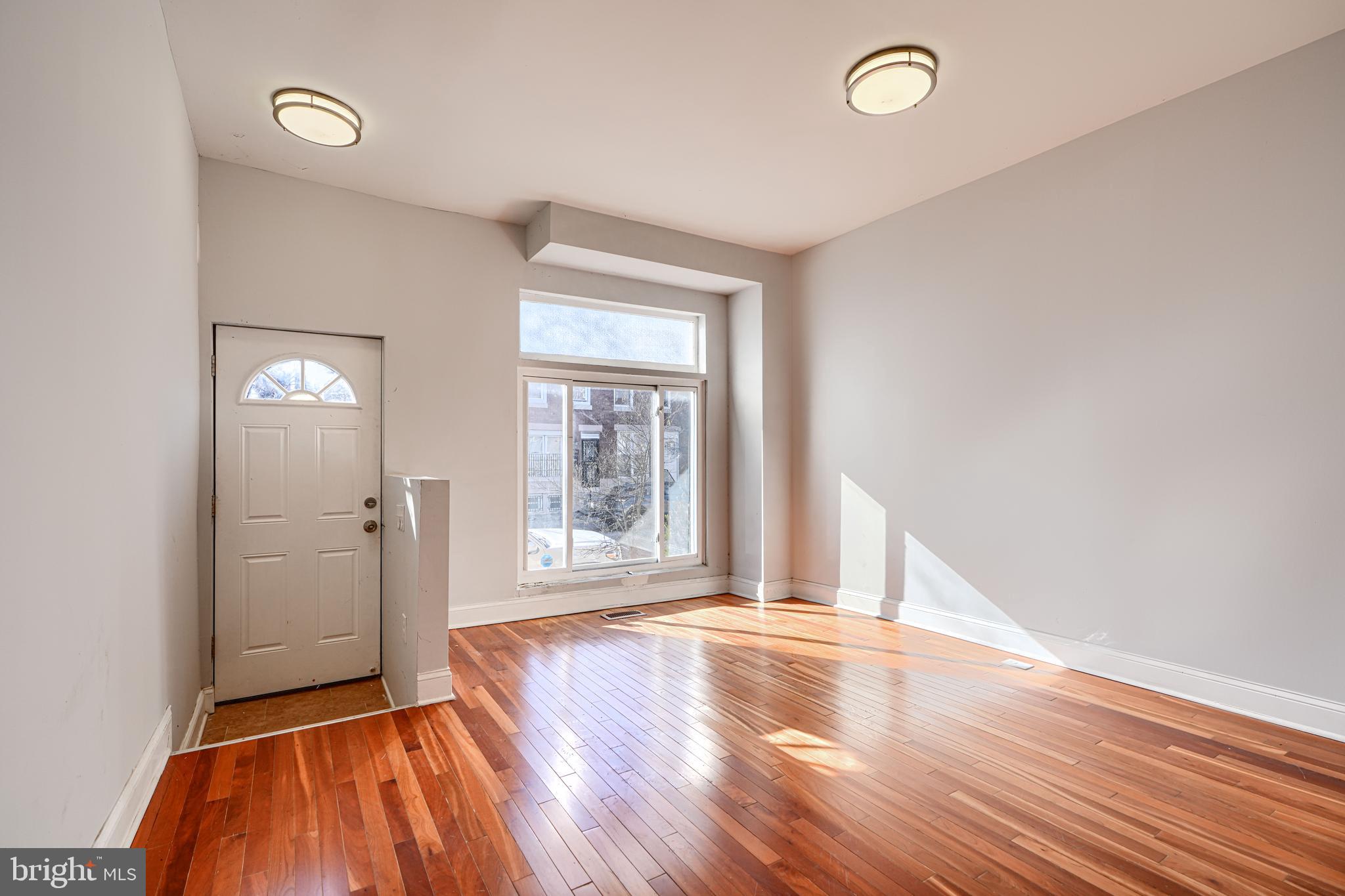 2511 McCulloh Street Baltimore, MD 21217 - Photo 3 of 32 an empty room with wooden floor and windows