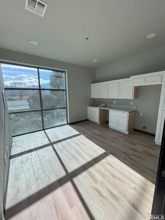 a view of a room with wooden floor and furniture