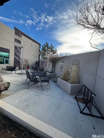 a building outdoor space with patio furniture and potted plants