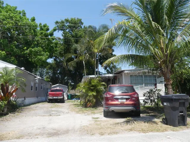 a front view of a house with cars parked