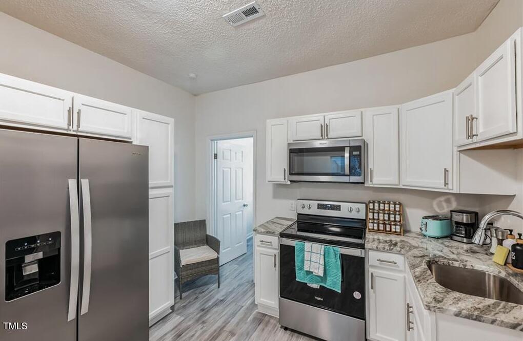 1512 Pender Street Raleigh, NC 27610 - Photo 7 of 12 a kitchen with a refrigerator stove and microwave